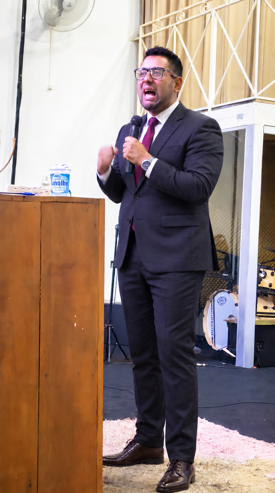 Pr Cristian Mendes pregando com um microfone na igreja